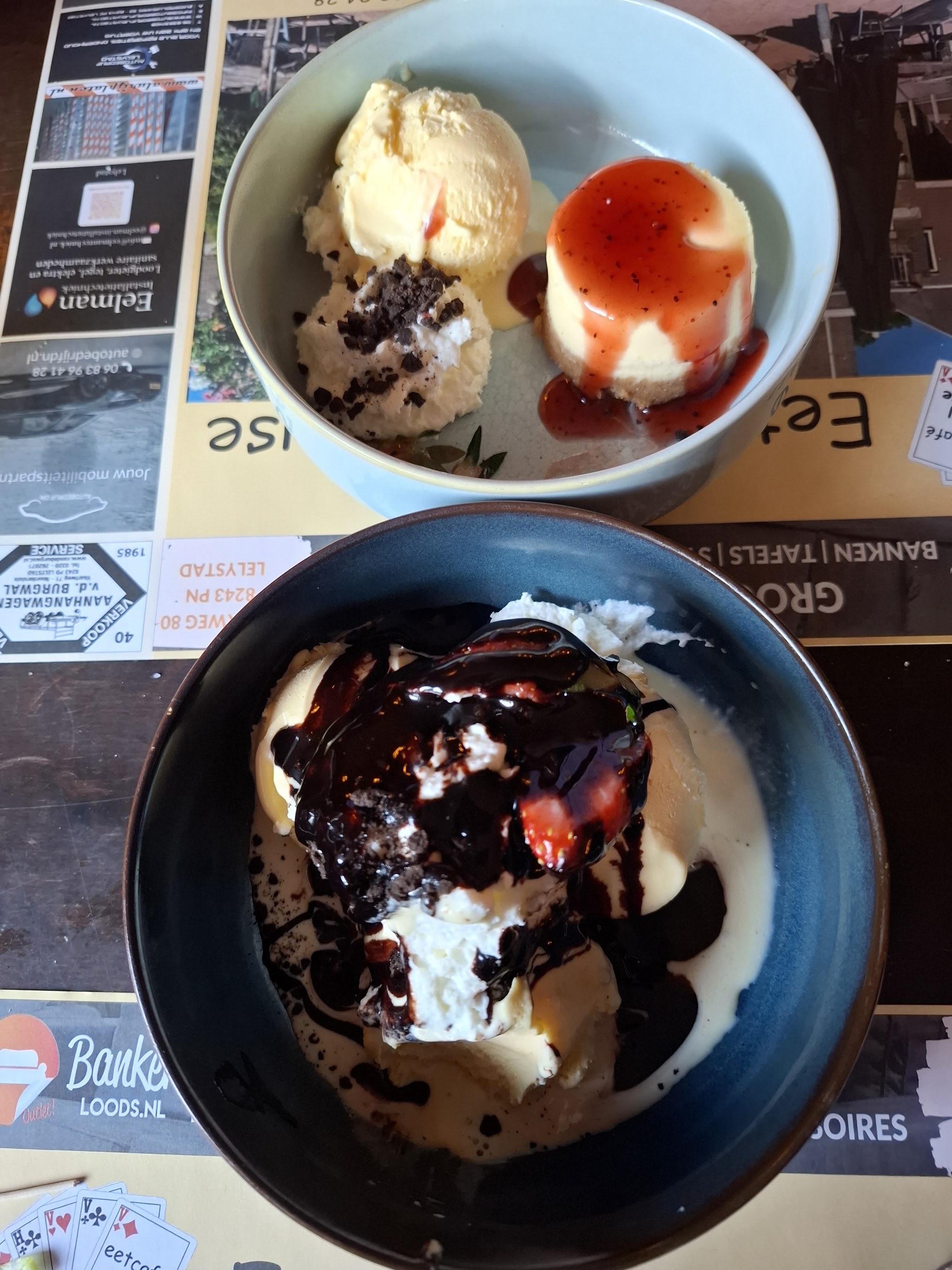 Twee desserts met ijs, slagroom en chocoladesaus